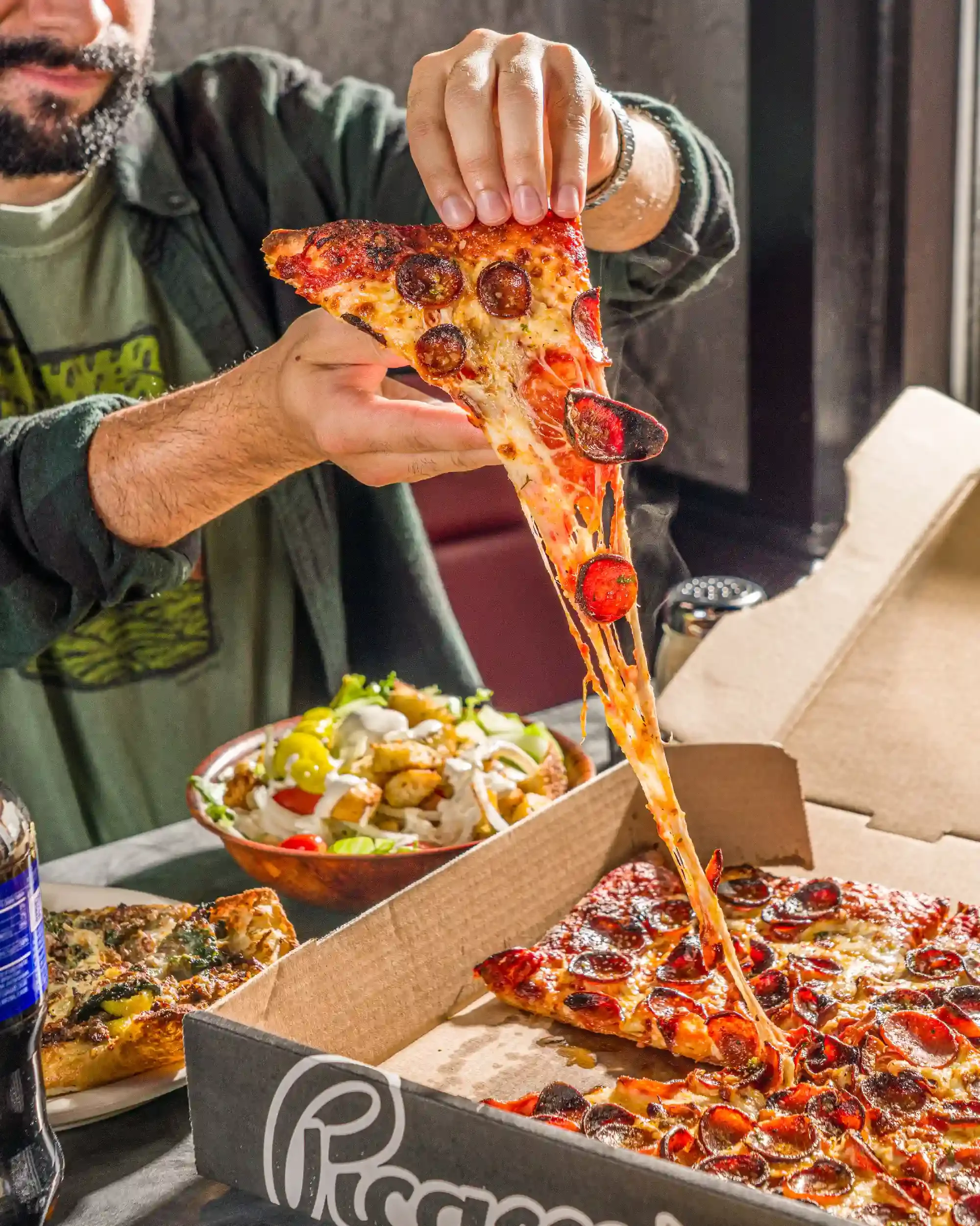 guy-pulling-pizza-slice-out.webp