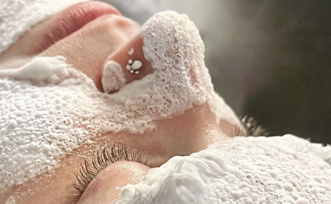 Nahaufnahme eines Gesichts während einer Gesichtswäsche mit Schaum