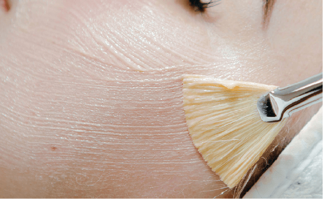 Jemand trägt Hautpflegecreme auf die Haut auf.