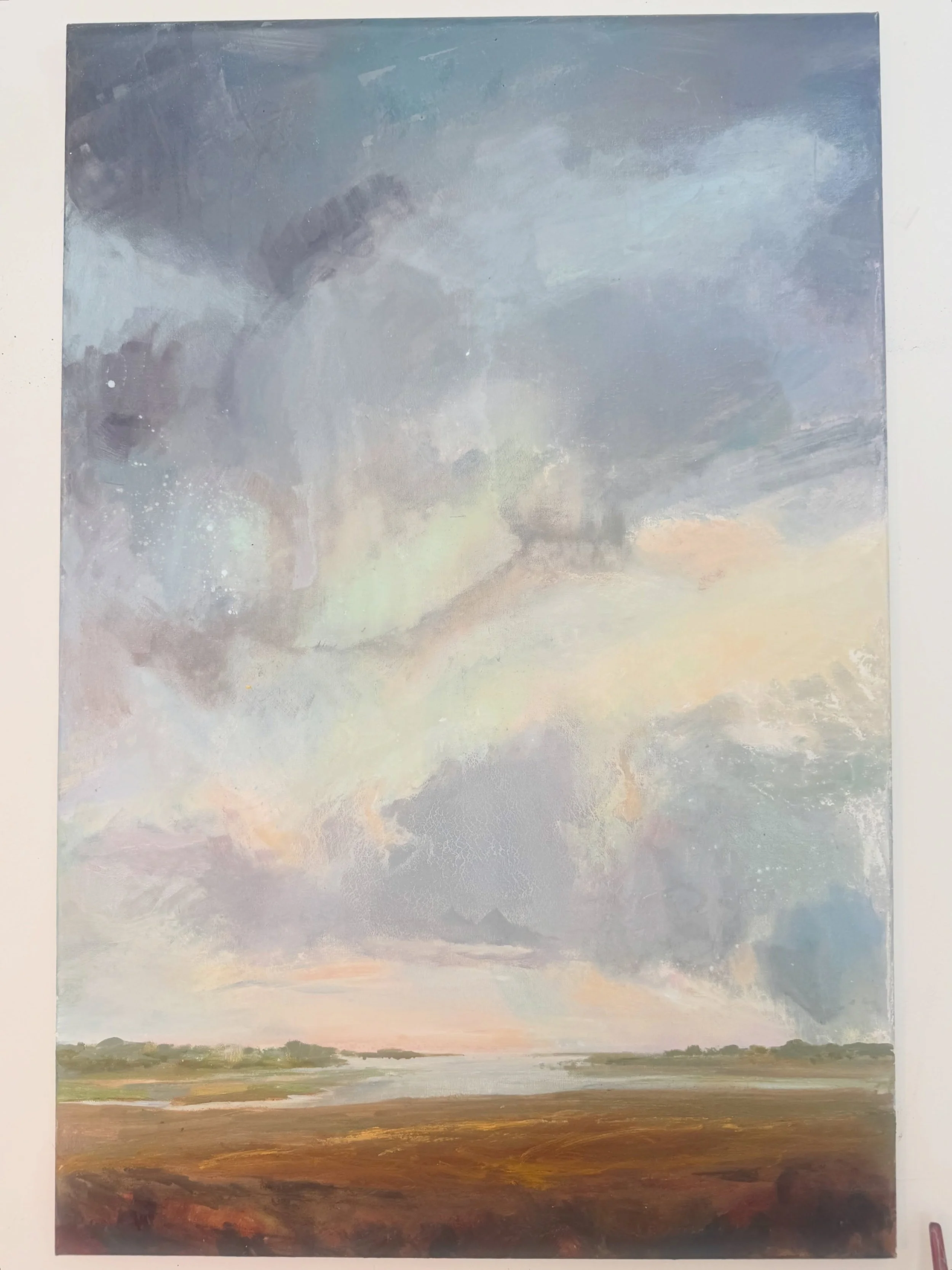 An oil painting that is a work in progress. My approach is intuitive painting. I grab hold of a mood that I&rsquo;ve seen when the clouds and the land meet. I apply the colors that speak to the harmony of the mood and then I let the paint and the med