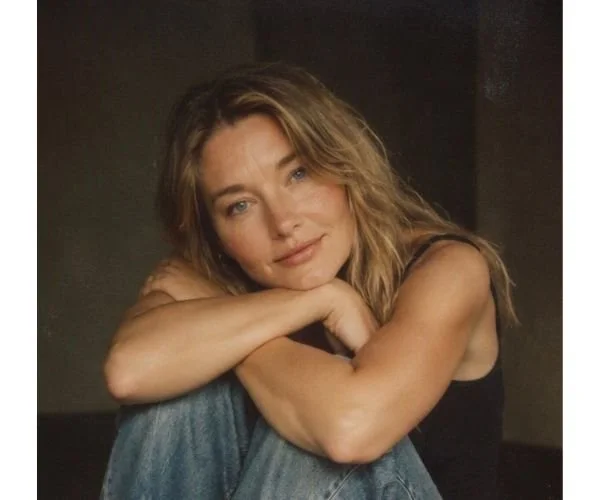 Kelli Lane Redfield, LMFT - therapist with wavy blond hair, stairing at camera, arms crossed, black tanktop, studio lighting.