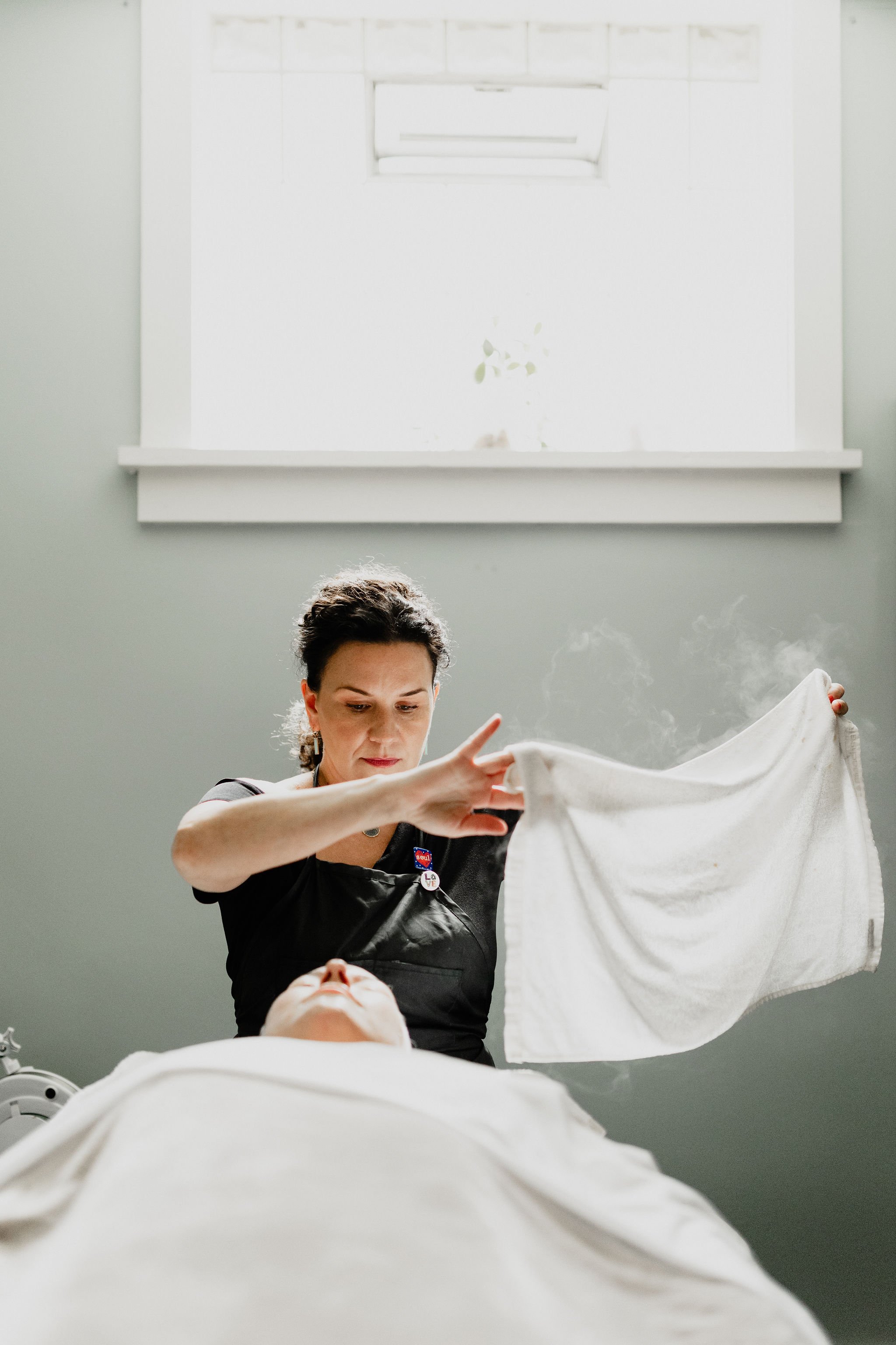 Health care professional preparing a woman for examination in a clinical setting.