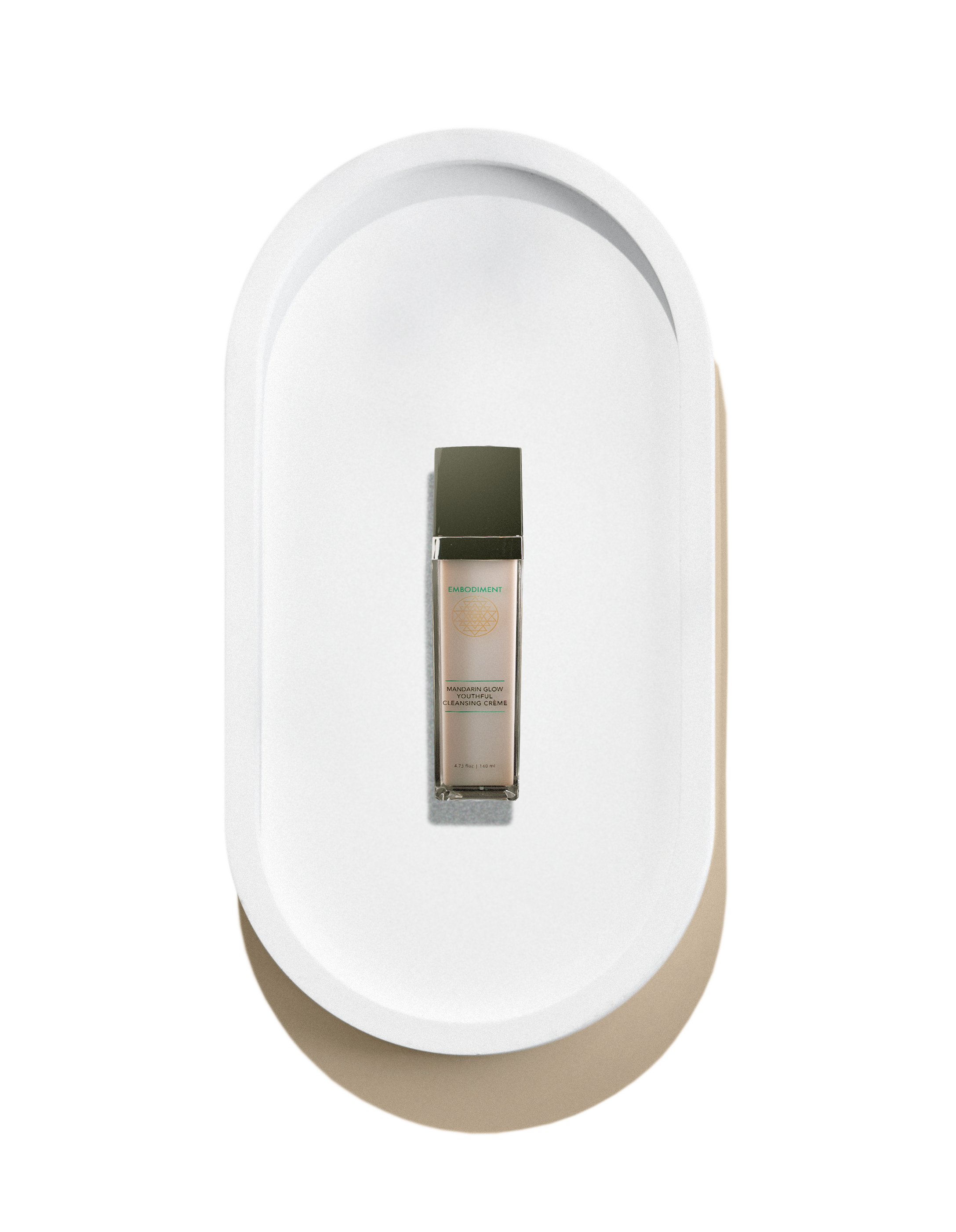 A skincare product in a clear bottle with a black cap, placed on a white oval tray.