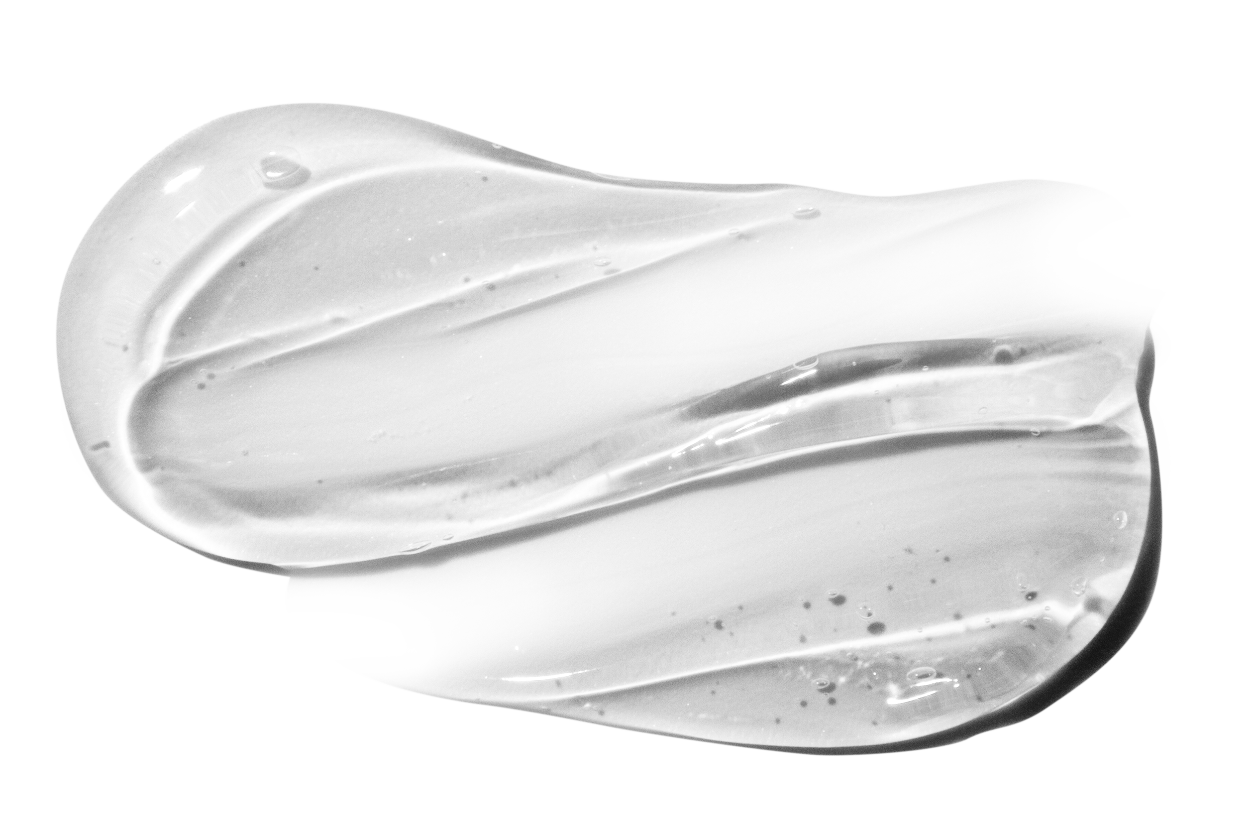 Two dollops of white cream or lotion smeared on a black background.