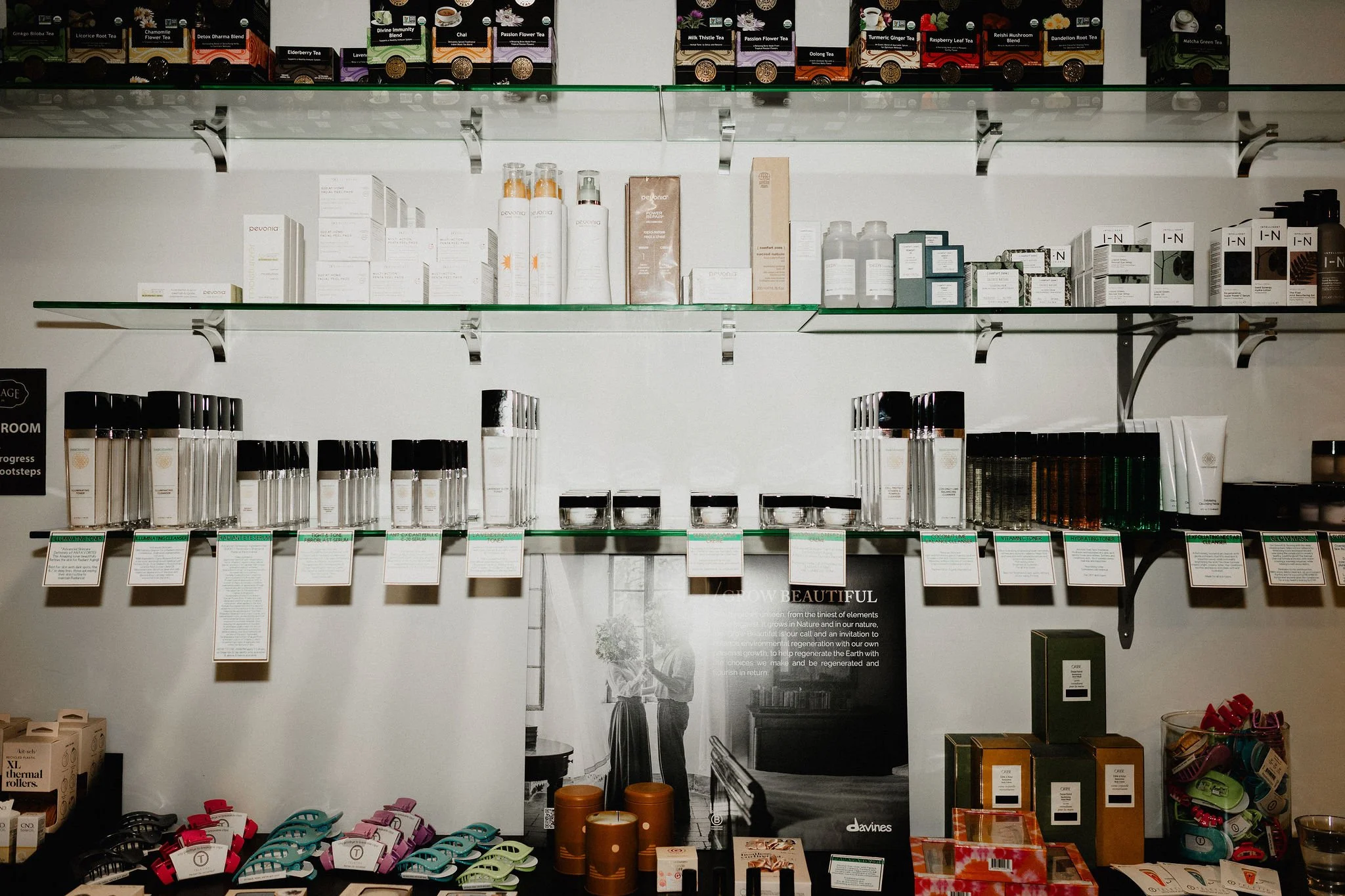 Display shelf with skincare products, candles, tea, and small accessories in a store.