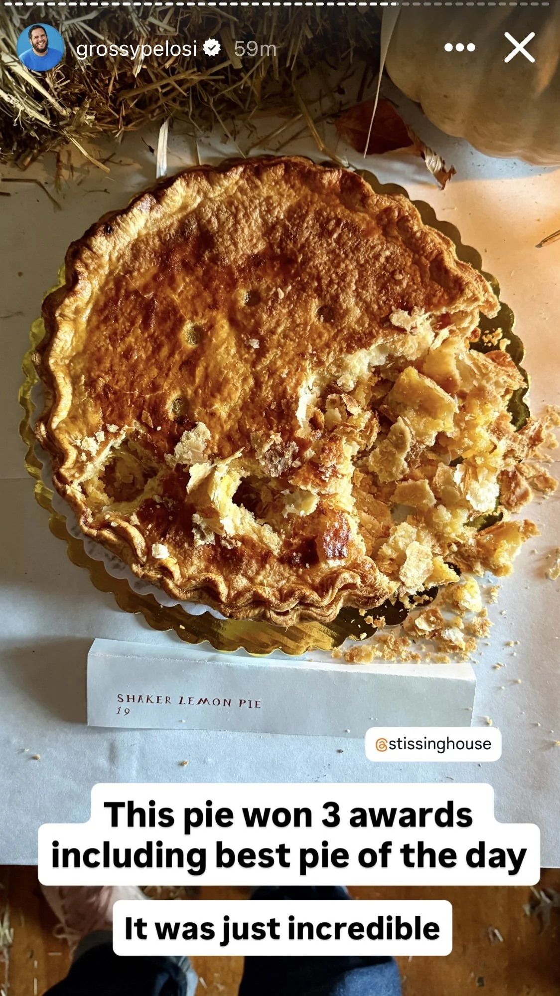 A partially eaten lemon pie with a golden, flaky crust and yellow filling, placed on a white surface with autumn decorations around, announcing it as an award-winning pie.