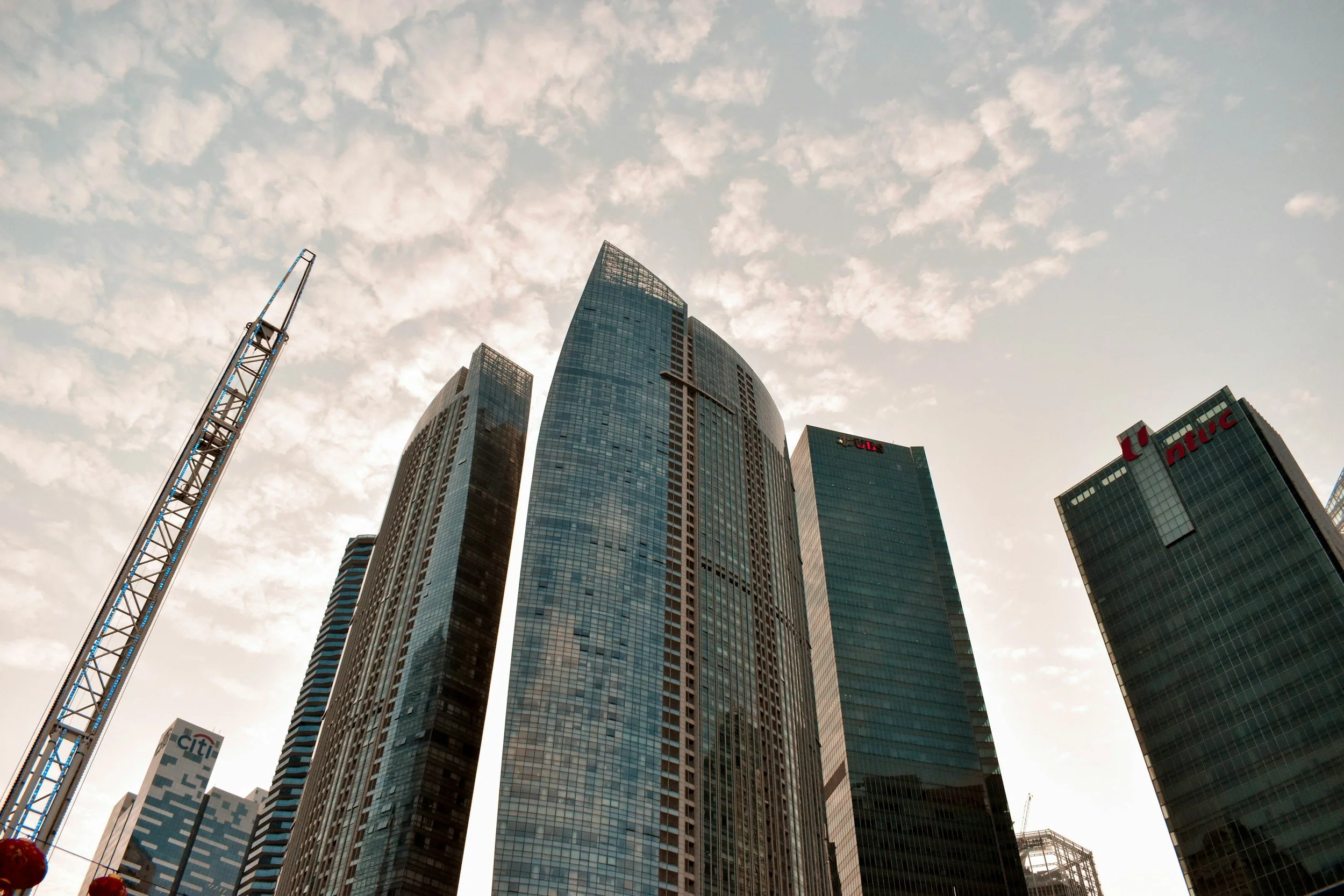 A city skyline with tall glass skyscrapers under a cloudy sky.