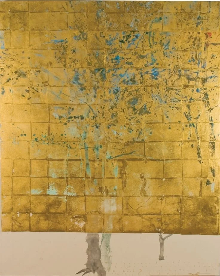 Abstract painting of a tree with a yellow background and blue splashes, with two tree trunks at the base.
