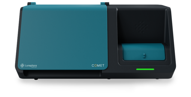 A turquoise and black medical device with a small digital screen and a slot for inserting a test strip, labeled 'Lunaphore COMET'.