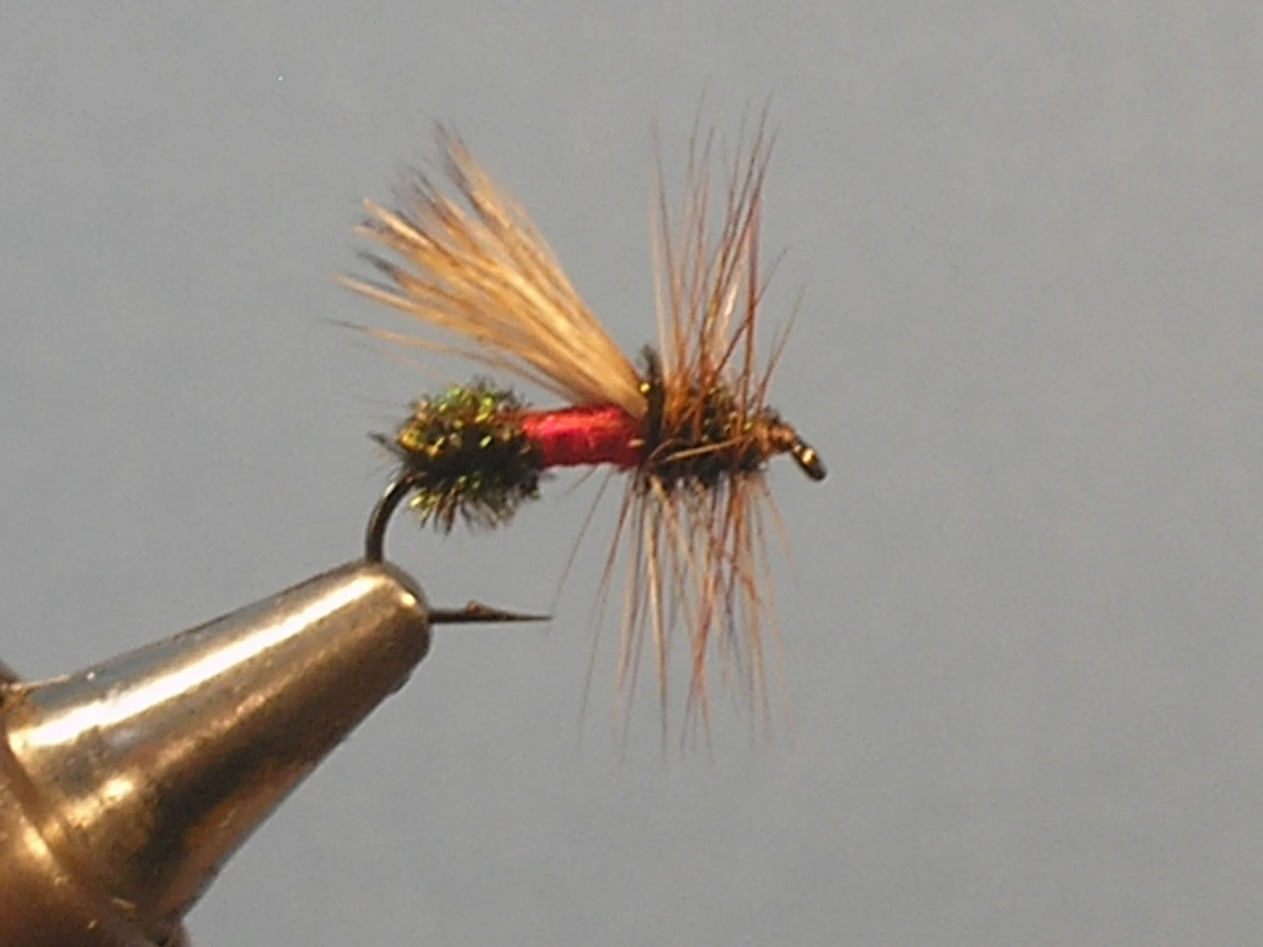 Close-up of a fishing fly tied on a hook.