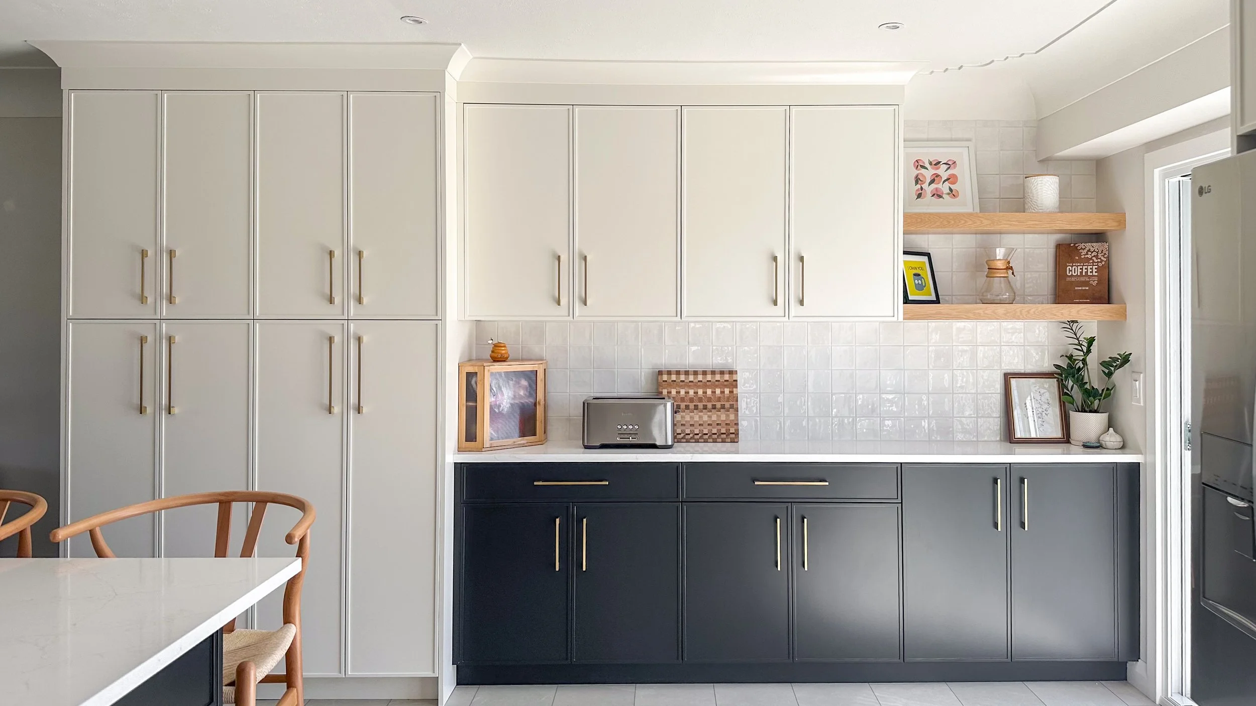 A full view of the new storage and prep wall. We combined the massive floor-to-ceiling pantry cabinets with a dedicated countertop zone for the toaster and coffee station, keeping the main kitchen island completely clear for everyday cooking.