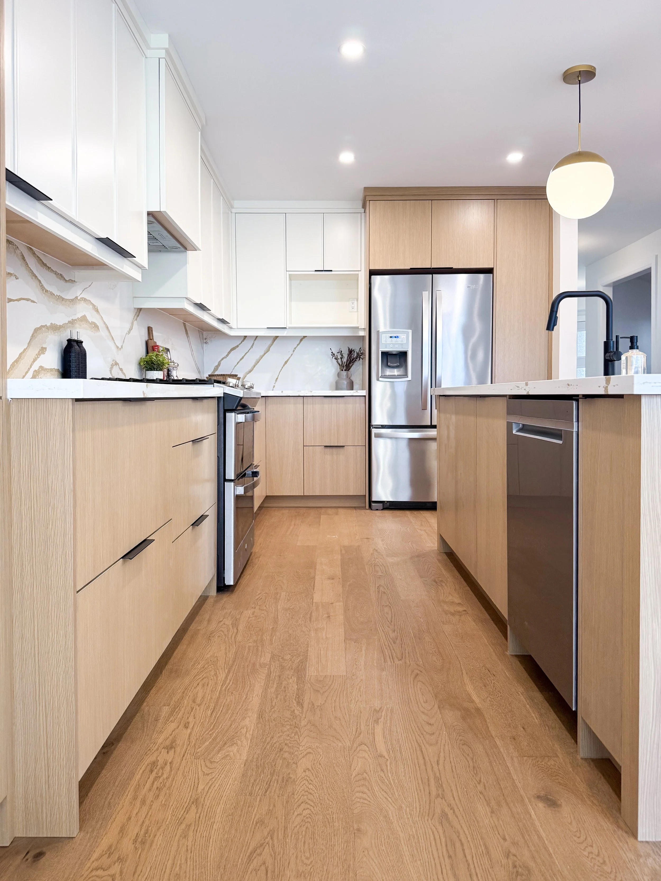 Functional Kitchen Layout with Custom Dual Tone White Oak and Painted Cabinetry and Updated Hardwood Floors.