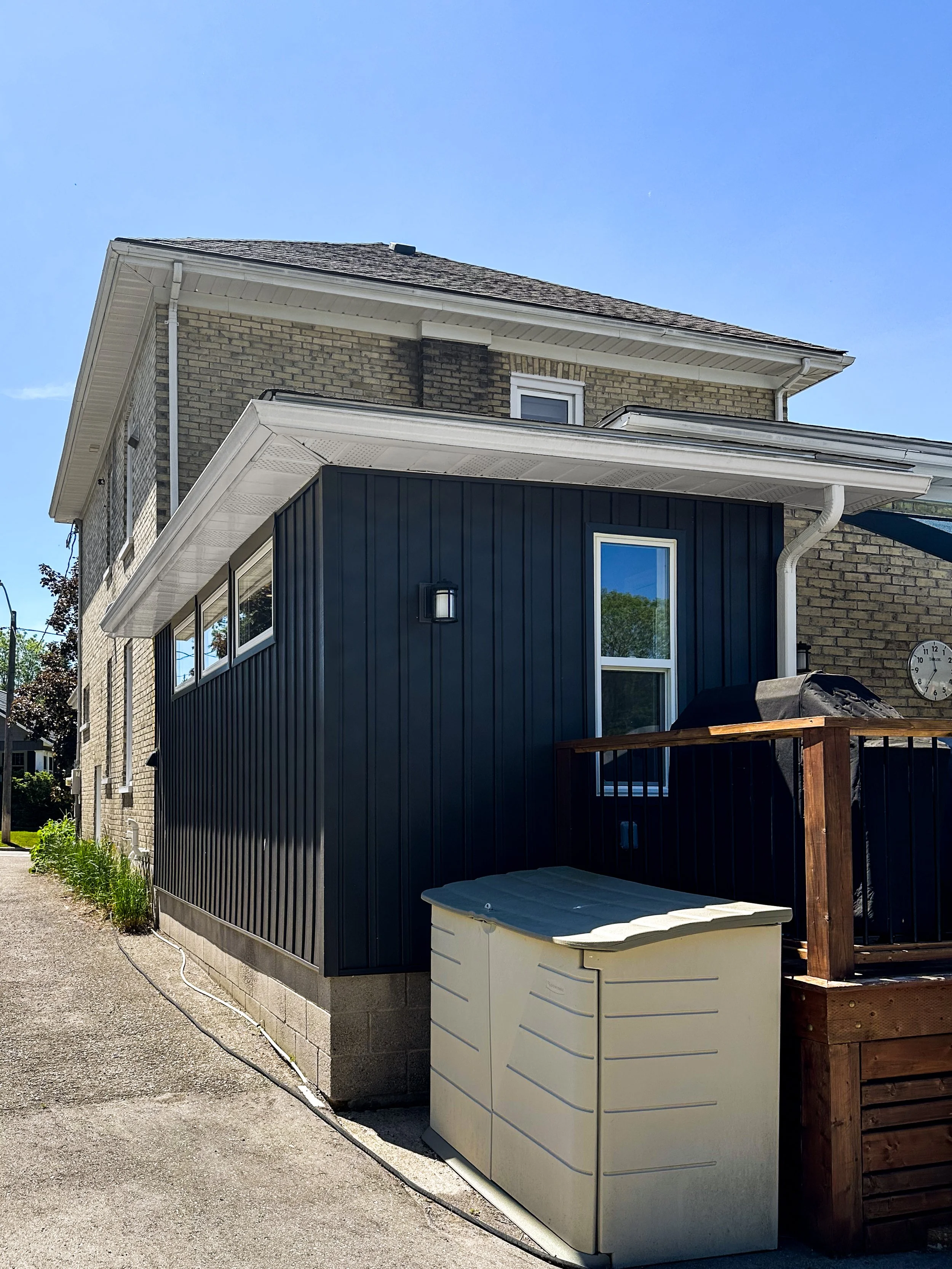 Custom exterior remodel in New Hamburg showcasing a modernized mudroom exterior with dark board and batten style siding.