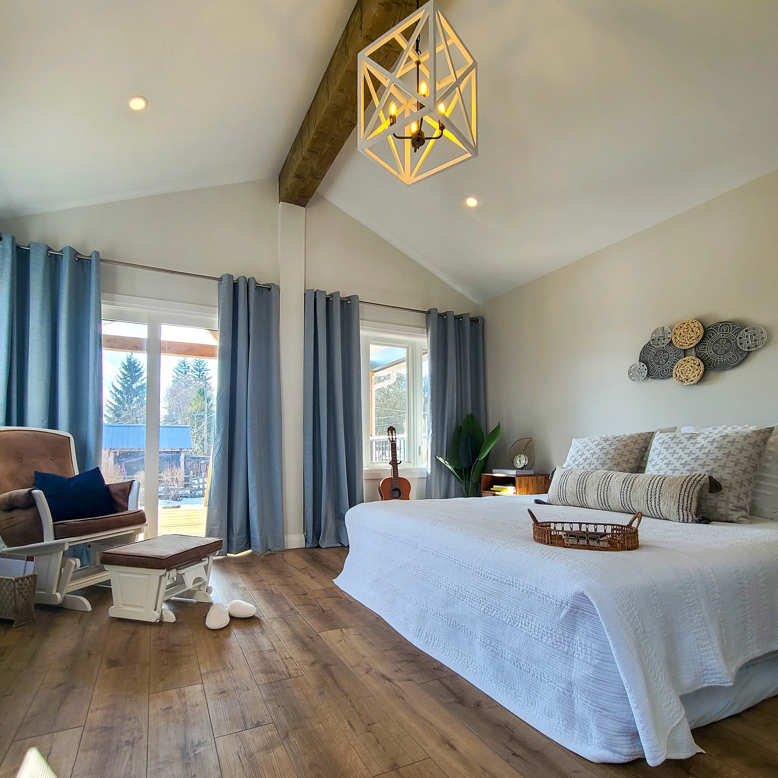 A bright, beautifully finished primary bedroom renovation with vaulted ceilings and wood beams completed by Catalyst General Contracting in Cambridge.