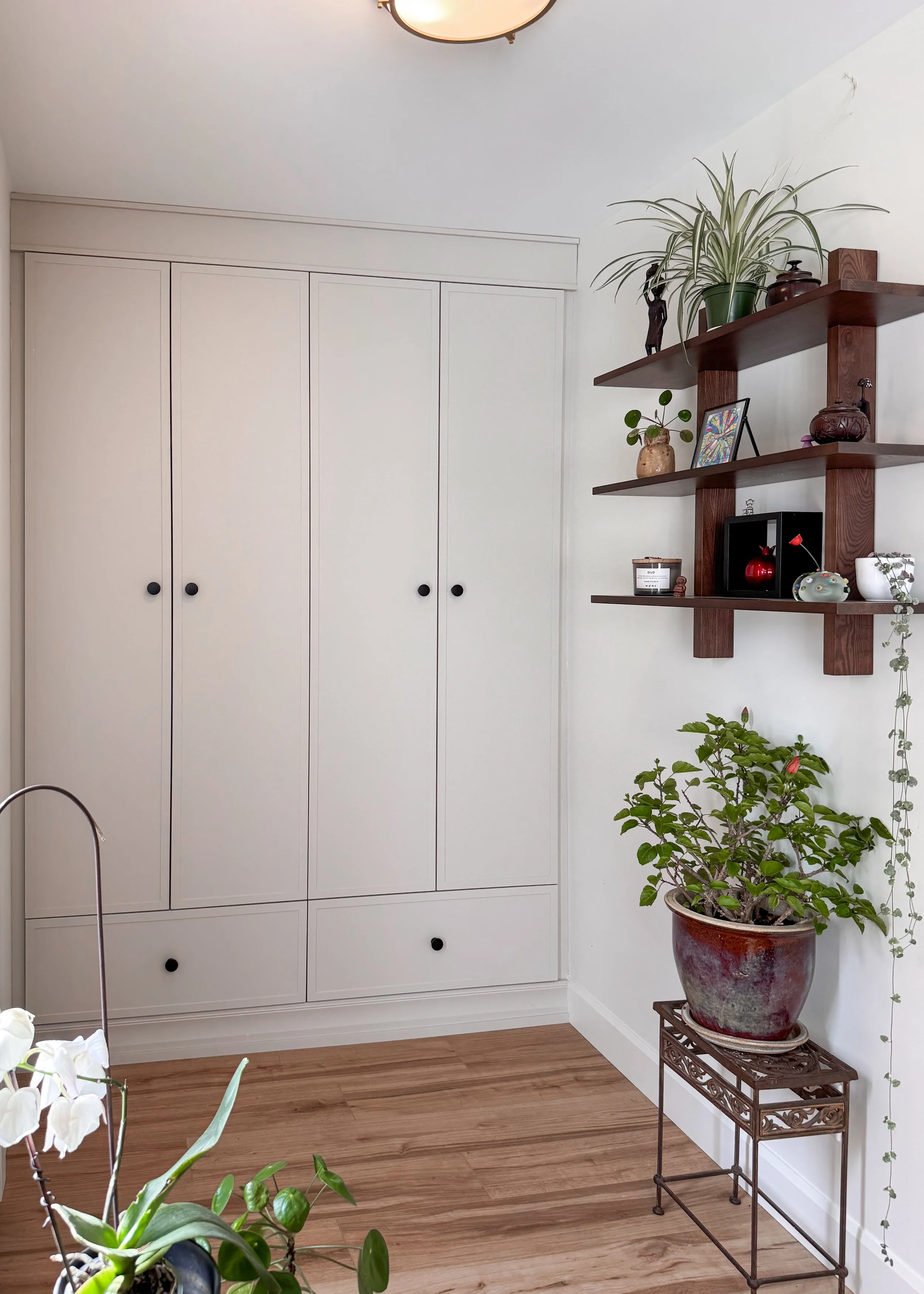 Off-white custom built-in closet system and matching wood floating wall shelves designed for smart home storage and organization in Waterloo, Ontario.