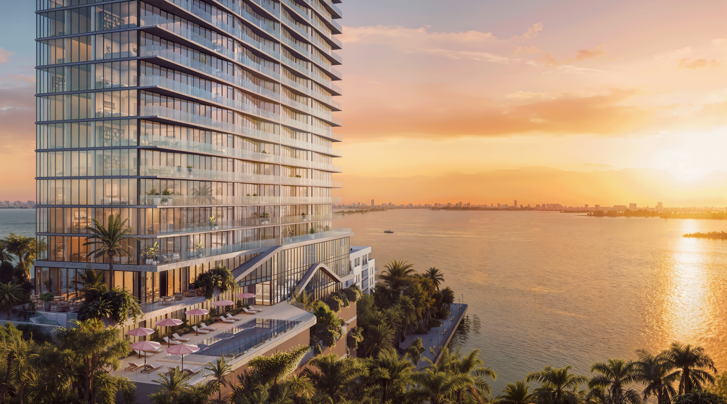 A modern high-rise building with glass balconies and a rooftop terrace overlooking a body of water at sunset, surrounded by palm trees and city skyline in the distance.