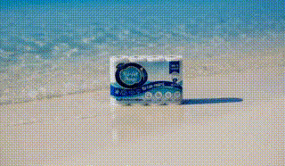 A box of Visa gift cards standing on white sand with the ocean in the background.