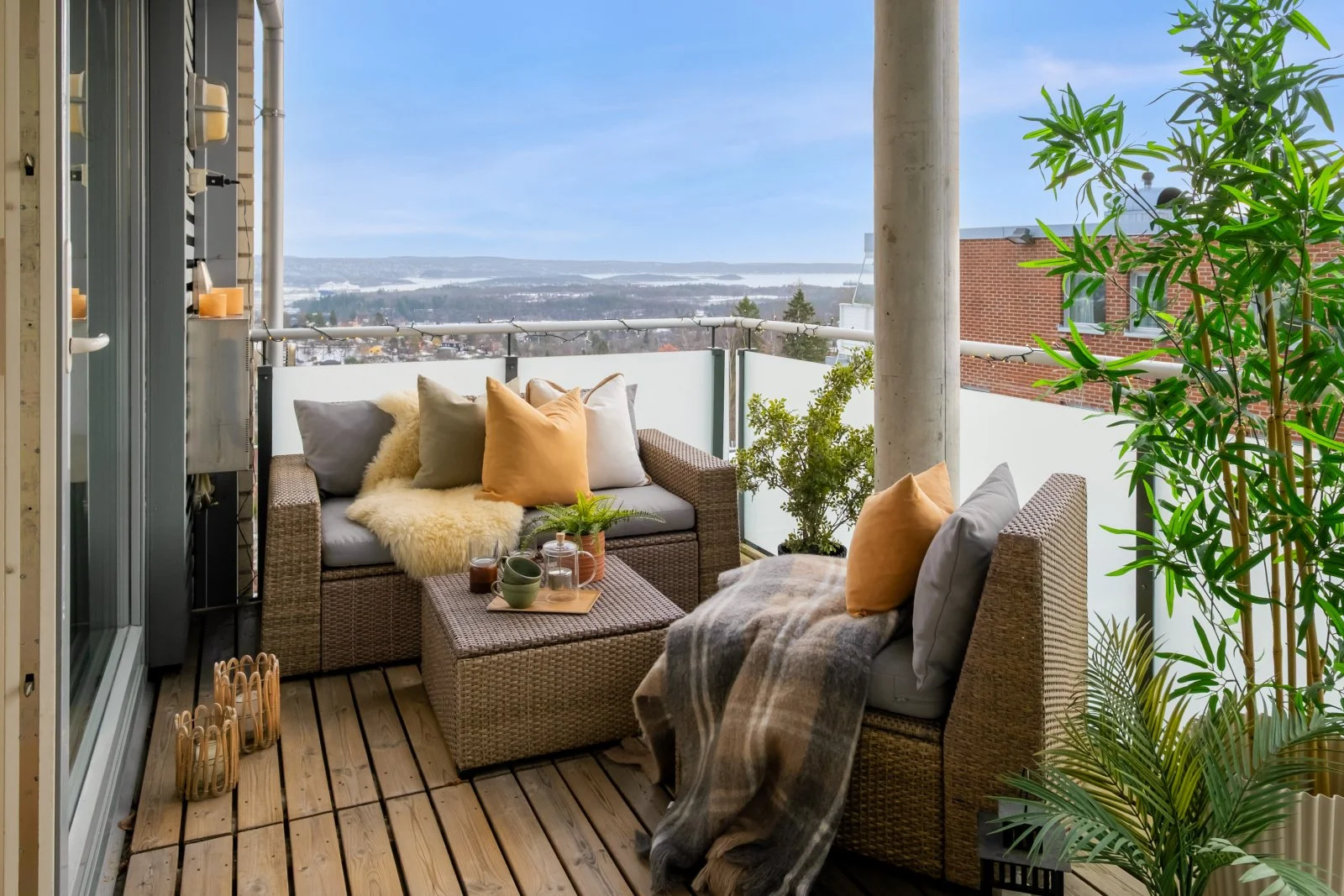 Image of a balcony with sofa, pillows and plants