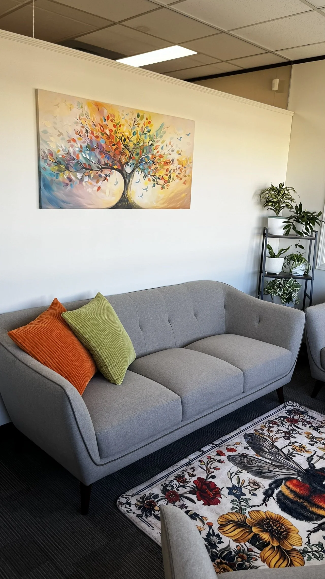 The long couch, rug and tree of life painting.