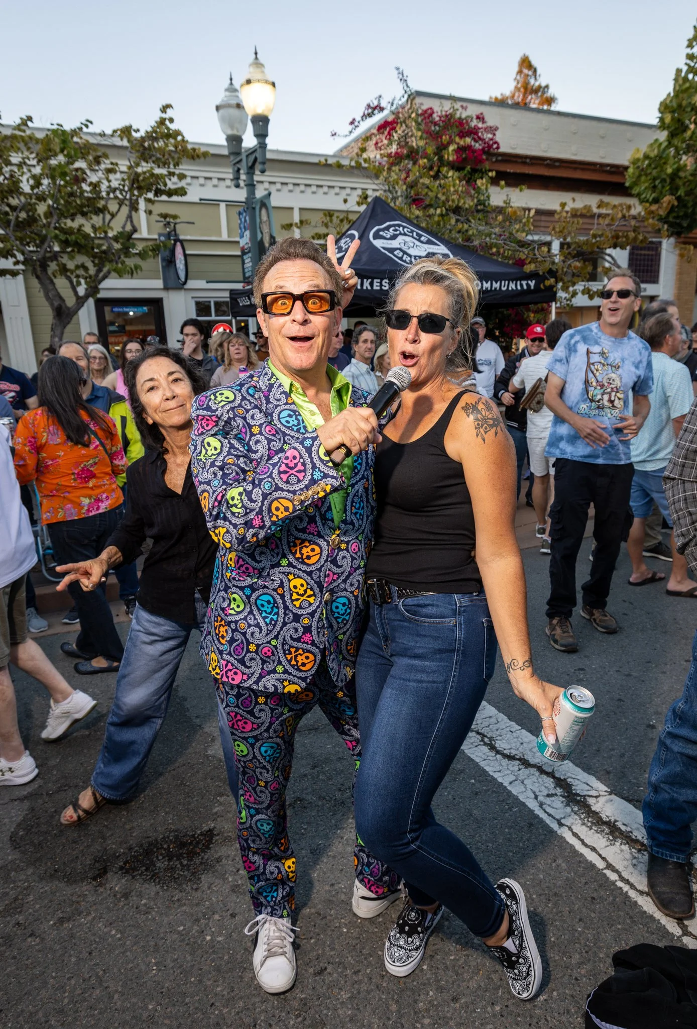 People dancing and enjoying themselves at Rock the Block on a Grant Ave., with a performer dressed in colorful, patterned clothing holding a microphone, in Downtown Novato California.