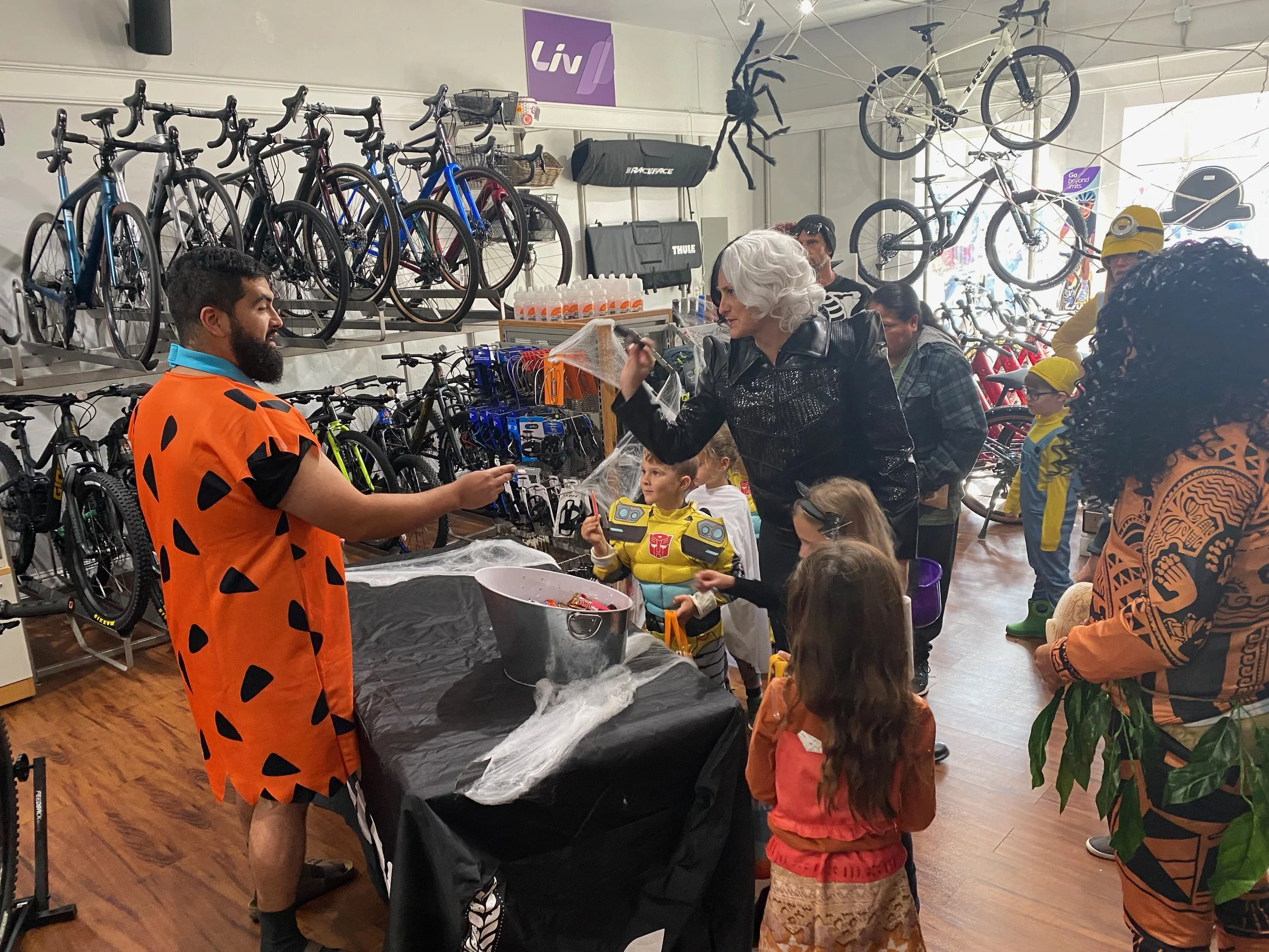 People dressed in Halloween costumes attending a Halloween-themed event in a bicycle shop, during Safe Trick or Treat, in Downtown Novato California.