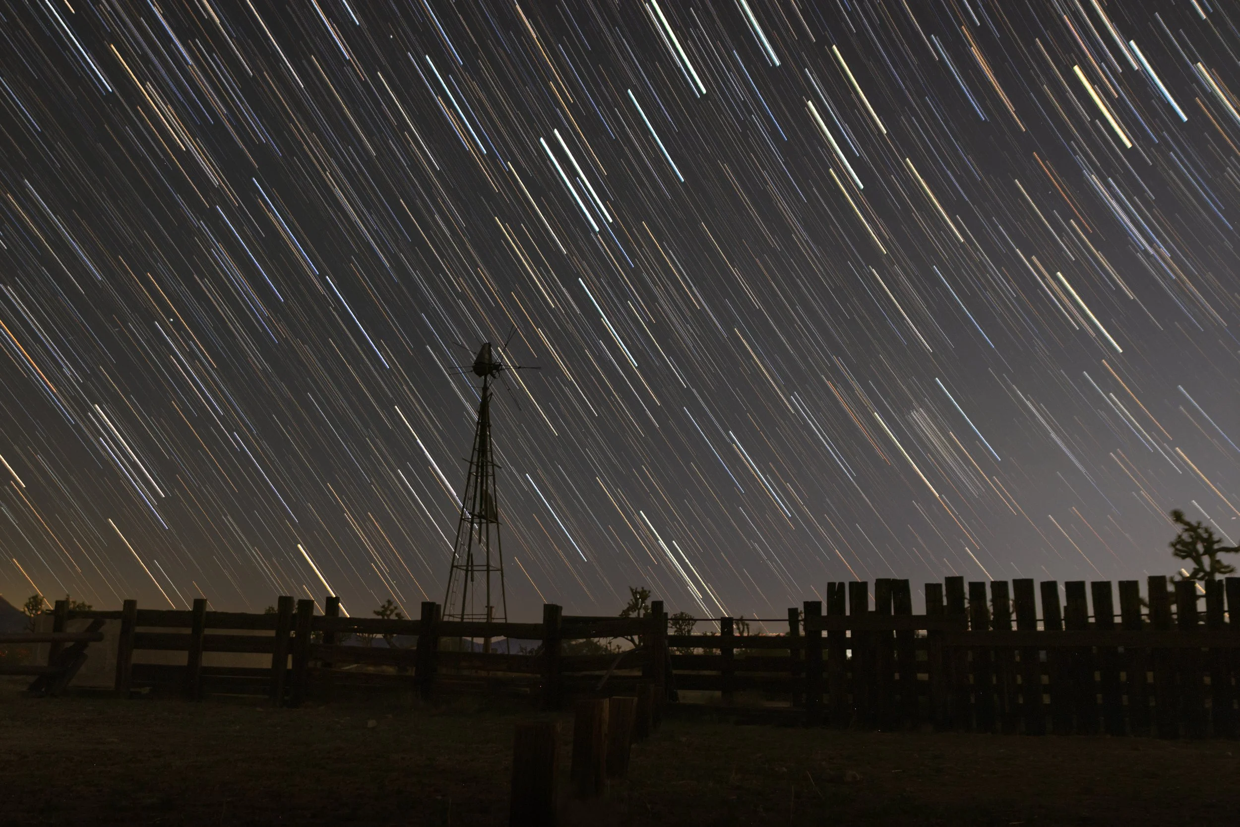 Cascading stars training against a silhouetted windmill and wooden fence
