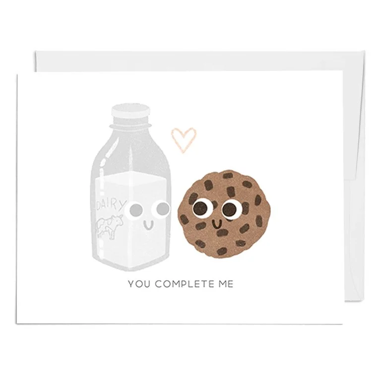 Cartoon illustration of a milk carton and a chocolate chip cookie with smiling faces, and a small pink heart above them, with the text 'You complete me' below.
