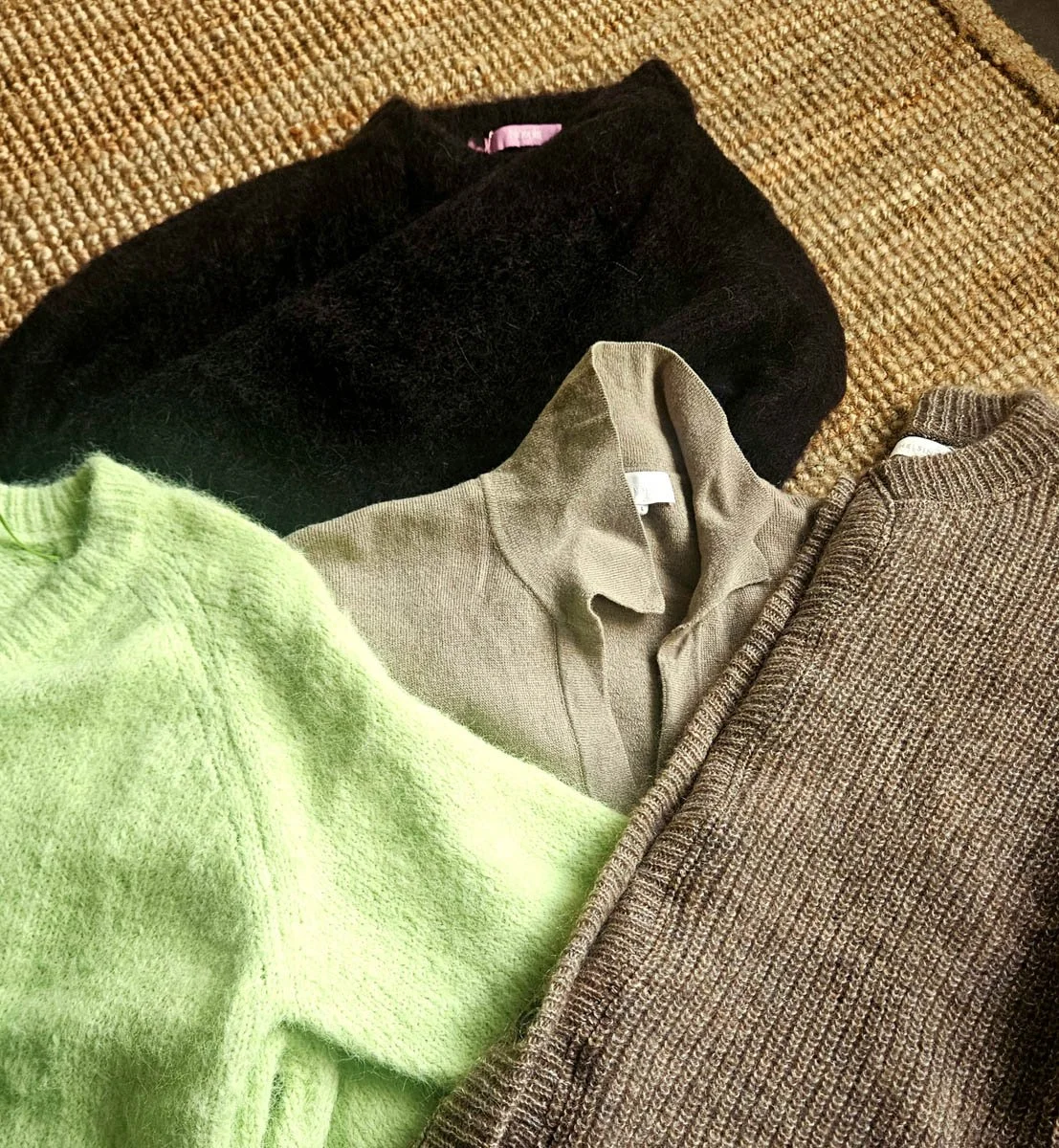Erivärisiä neulepuseroita aseteltuna päällekkäin.