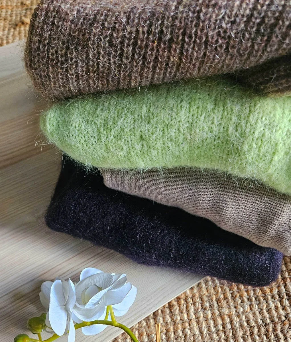 Neulepaitoja aseteltuna päällekkäin, niiden päällä on valkoinen orkideankukka.