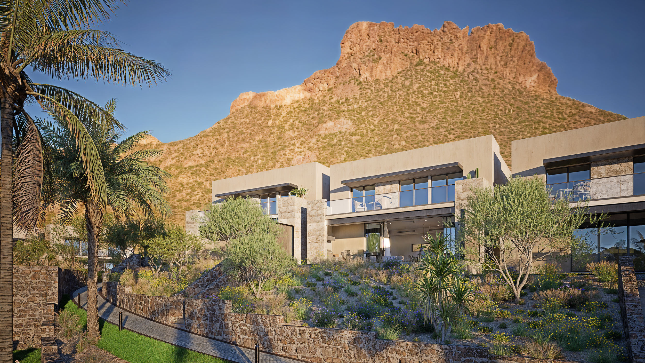 Residencial moderno con casas de nivel doble en un paisaje desértico con montañas de fondo y vegetación seca, cactus y palmeras, con camino pavimentado.
