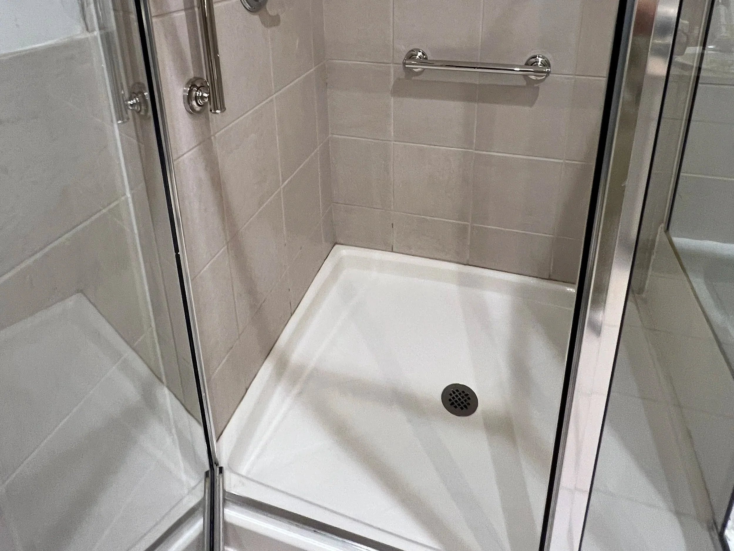 This shower stall floor has be treated to prevent slips and falls. This treatment improves the  shower safety by preventing  accidents.