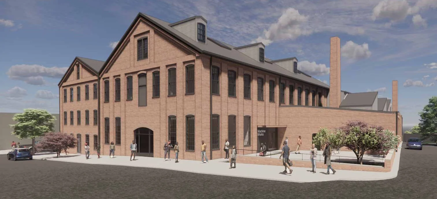 Render of a historic brick building with multiple stories, large windows, and a pitched roof, surrounded by trees, people walking on the sidewalk, parked cars, and a clear partly cloudy sky.