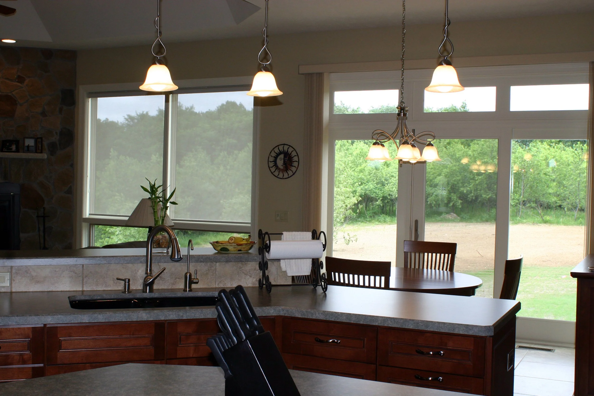 Kitchen view showing counter, sink area, dining area with large french doors and windows