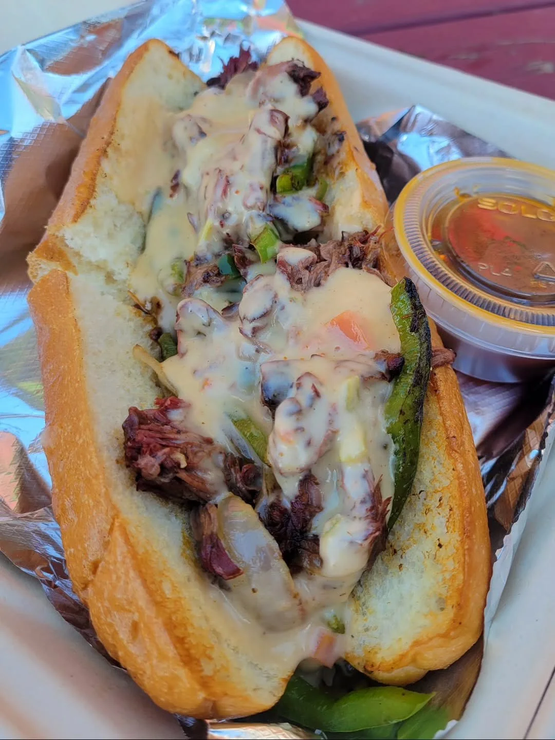 It starts on the griddle &mdash; your protein hitting the heat, peppers and onions softening into that perfect sizzle. Then comes the moment: a slow pour of hatch chile queso, melting into every corner. We pile it all into a toasted Amoroso roll and 