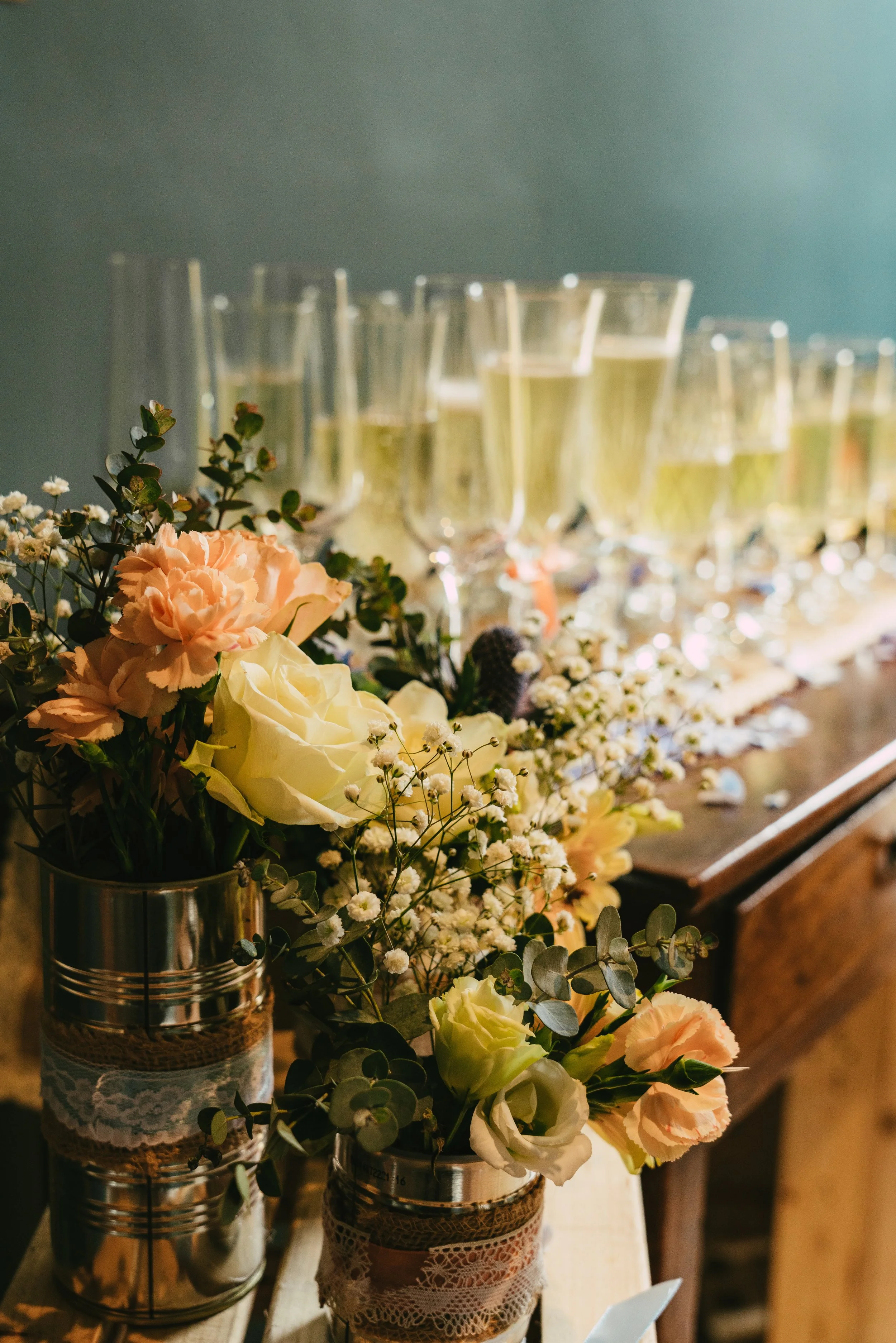 Floral arrangements with candles and glasses of champagne on a wooden table