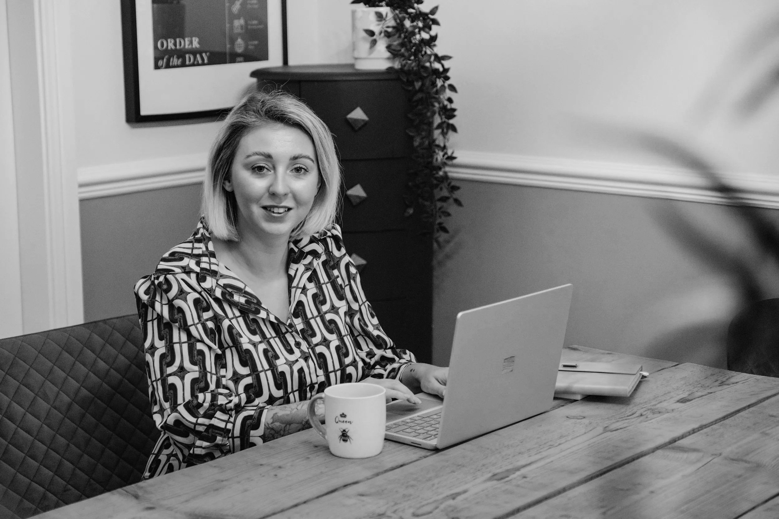 Cassie Marns, Founder of Marns Marketing, sitting at a desk with a laptop and a cup of tea.