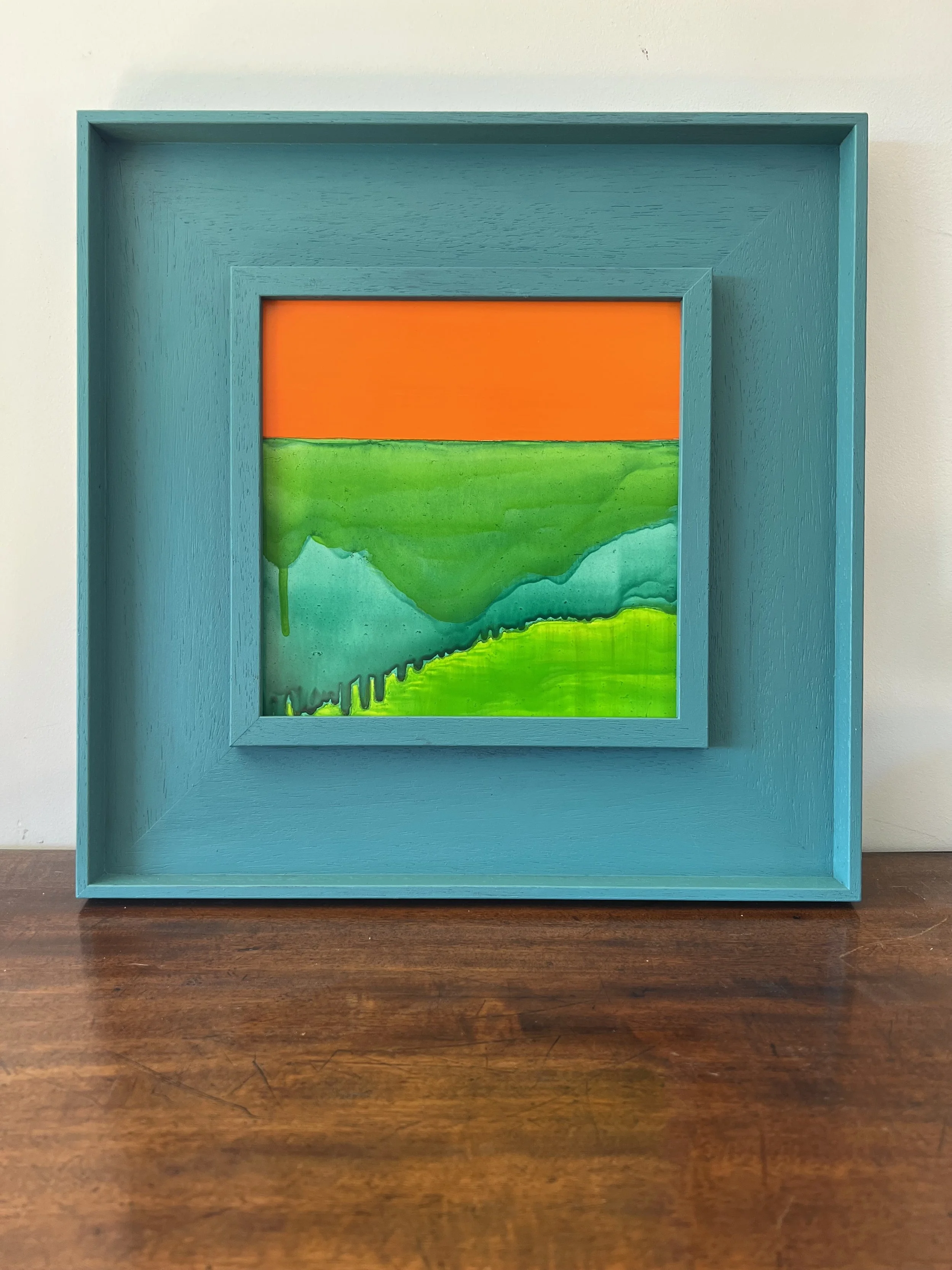 Orange and Green abstract oil painting in a hand painted St Ives Frame sitting on a table