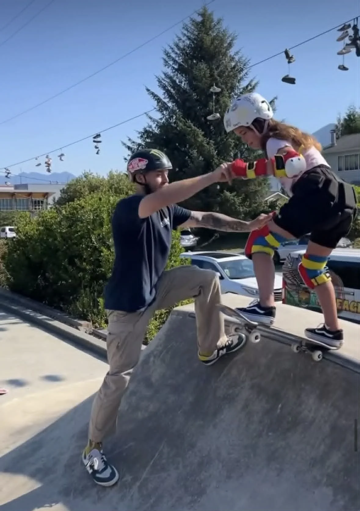 a surf and skate instructor doing a skateboard lesson for a kid in tofino
