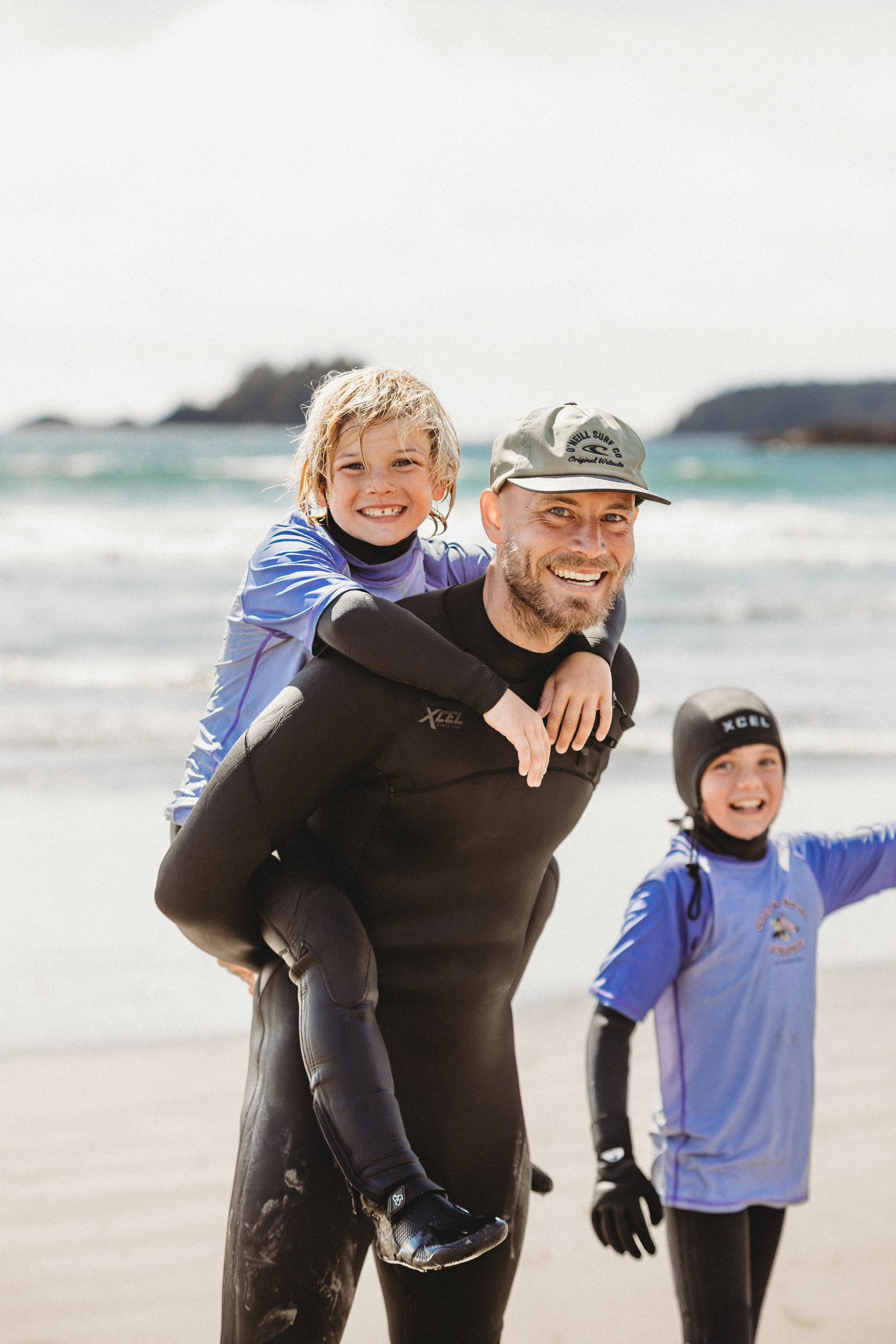 coastal shred academy is known for kids, family and beginner surf lessons. this is instructor aaron with kids having fun surfing and at north chesterman beach tofino