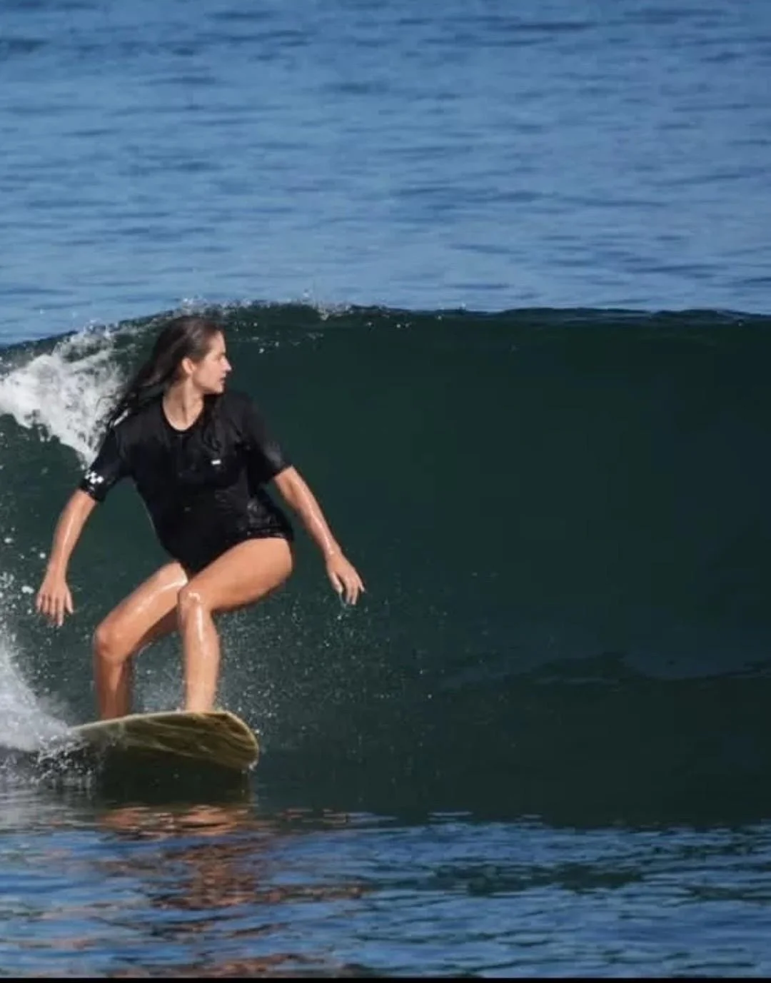 female surf instructor catching a wave and providing lessons in tofino and west coast