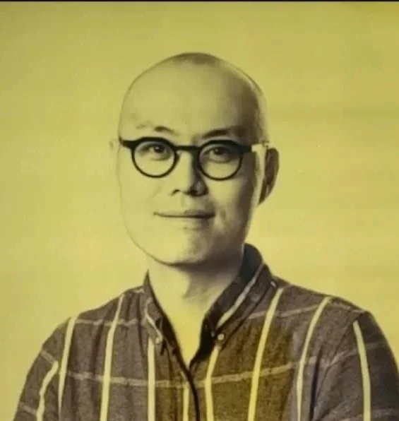 Headshot of Hang Xu, an Asian man wearing glasses and a checked shirt.