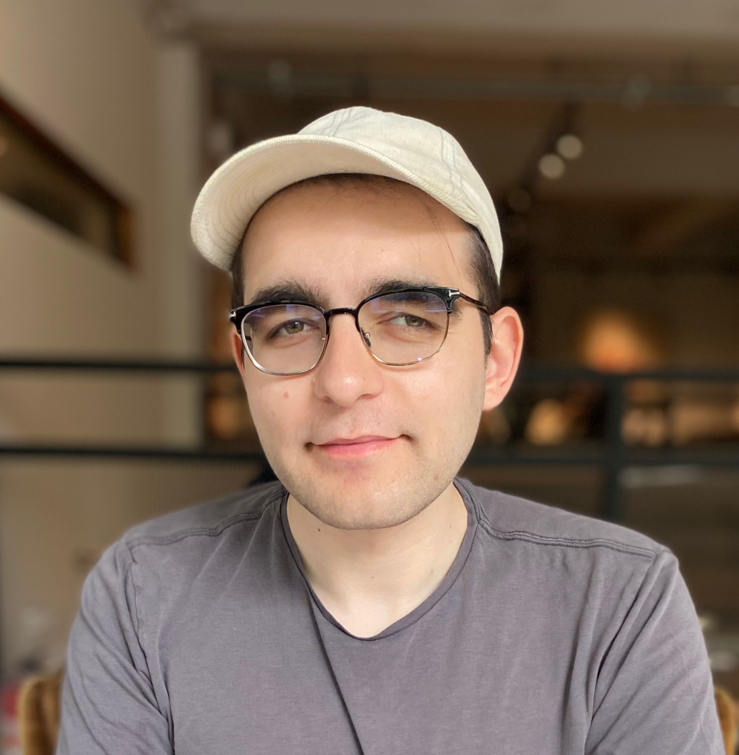 Headshot of Pavel Samsonov, a white man wearing glasses, a white ballcap, and a gray t-shirt.