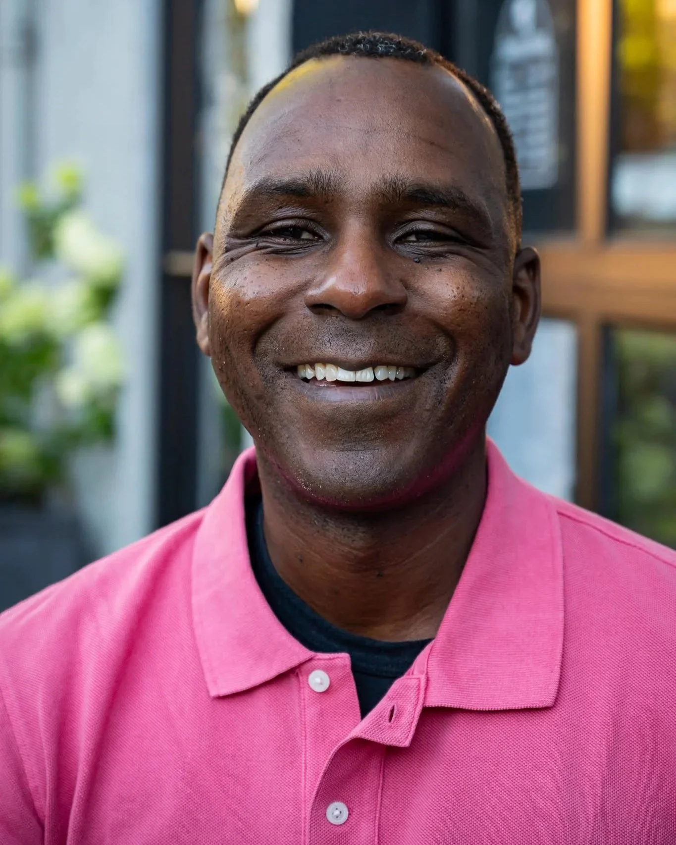 Headshot of Ron Bronson, a Black man wearing a pink collared shirt and smiling. 