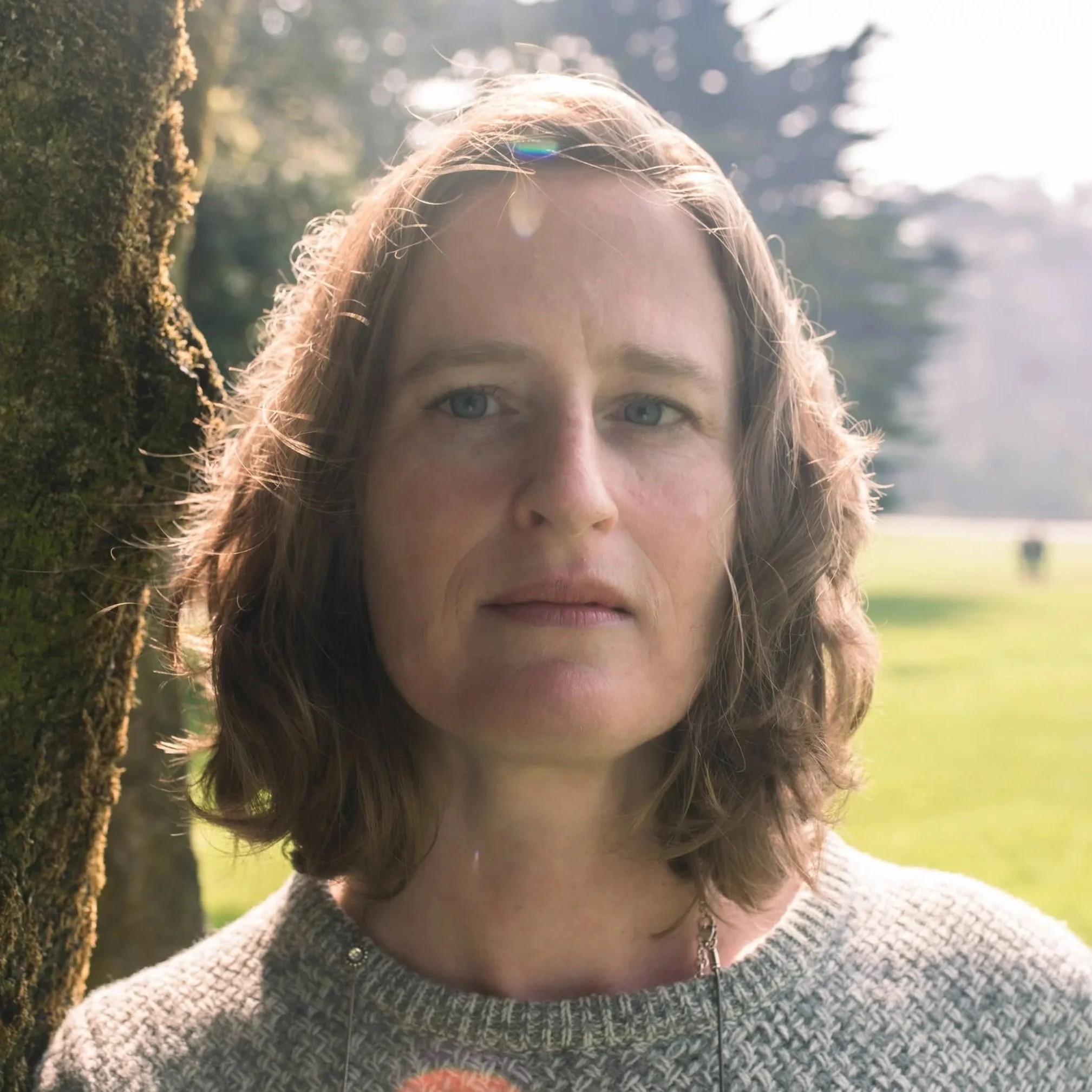 Headshot of Shawna Hein, a woman with blond hair wearing a gray sweater standing outside