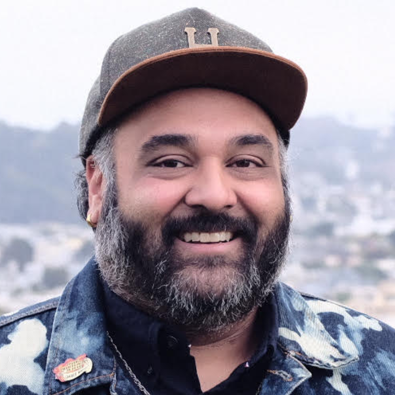 Headshot of Vinay Patel. He is a South Asian man wearing a ballcap and a beard.