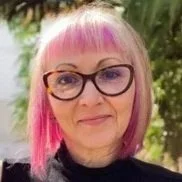 Headshot of Lisa Woodley, a white woman with pink hair and glasses.