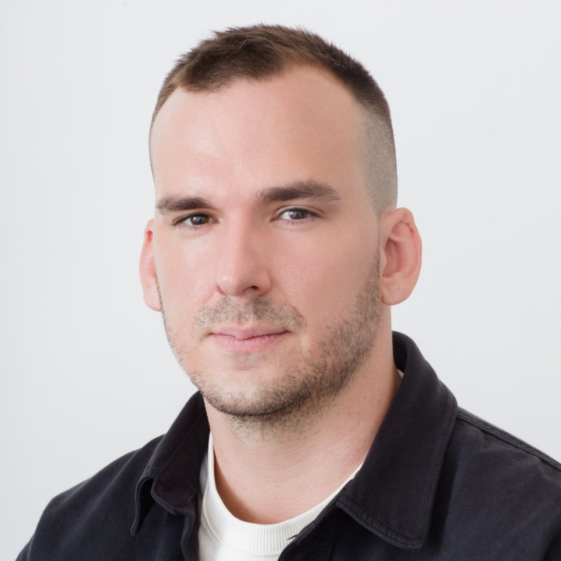 Headshot of Kyle Alexander, a white man with short dark hair wearing a white shirt and dark jacket.