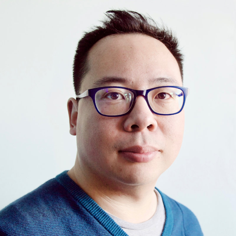 Headshot of Dan Hon, an Asian man with short dark hair and glasses wearing a blue t-shirt.