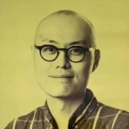 Headshot of Hang Xu, an Asian man with glasses and a checked shirt.