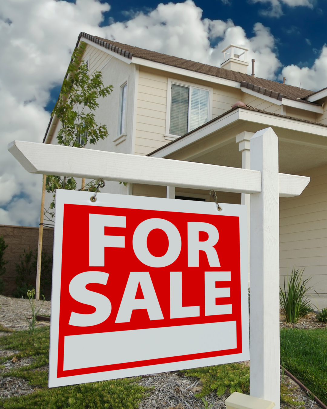 A house with a large 'For Sale' sign in the yard.